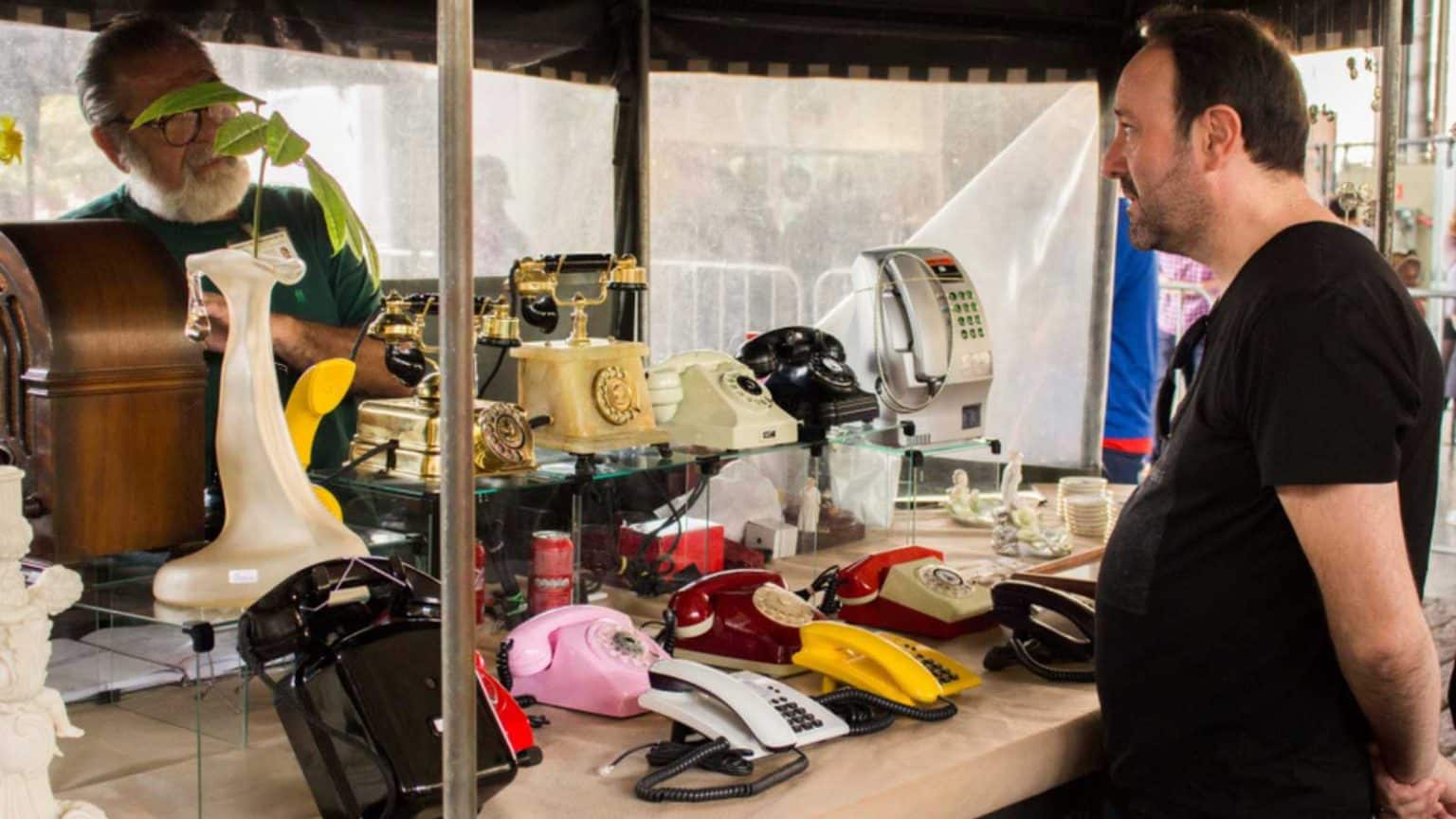 São Paulo / São Paulo / Brazil - 08 19 2018: Man with black shirt negotiating with a vintage telephone seller at a flea market