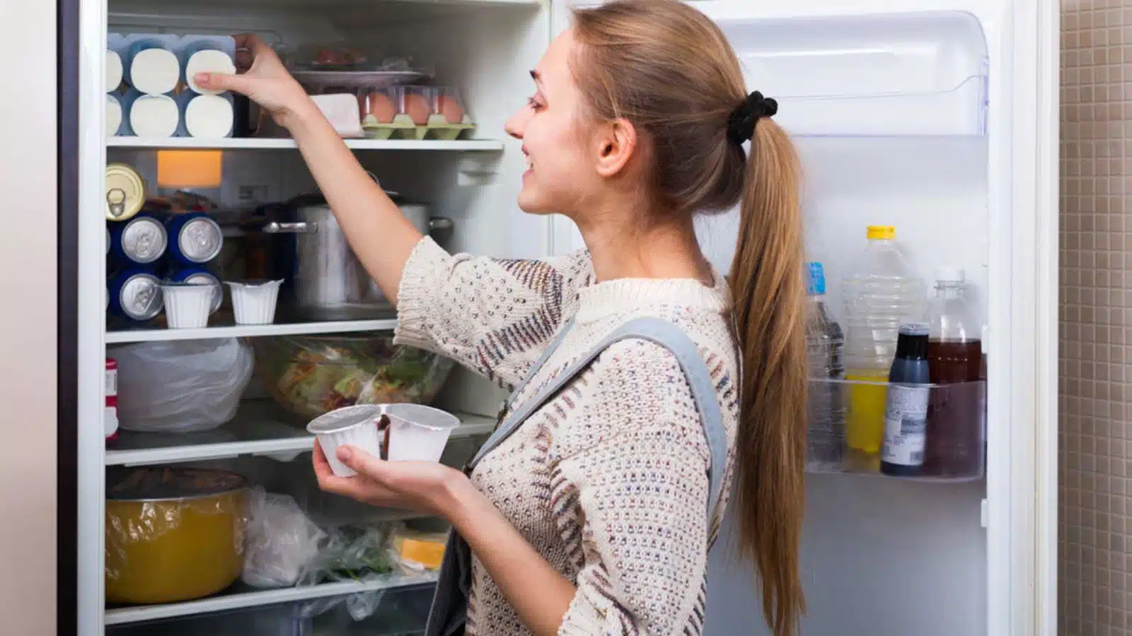 Woman keeping food in fridge