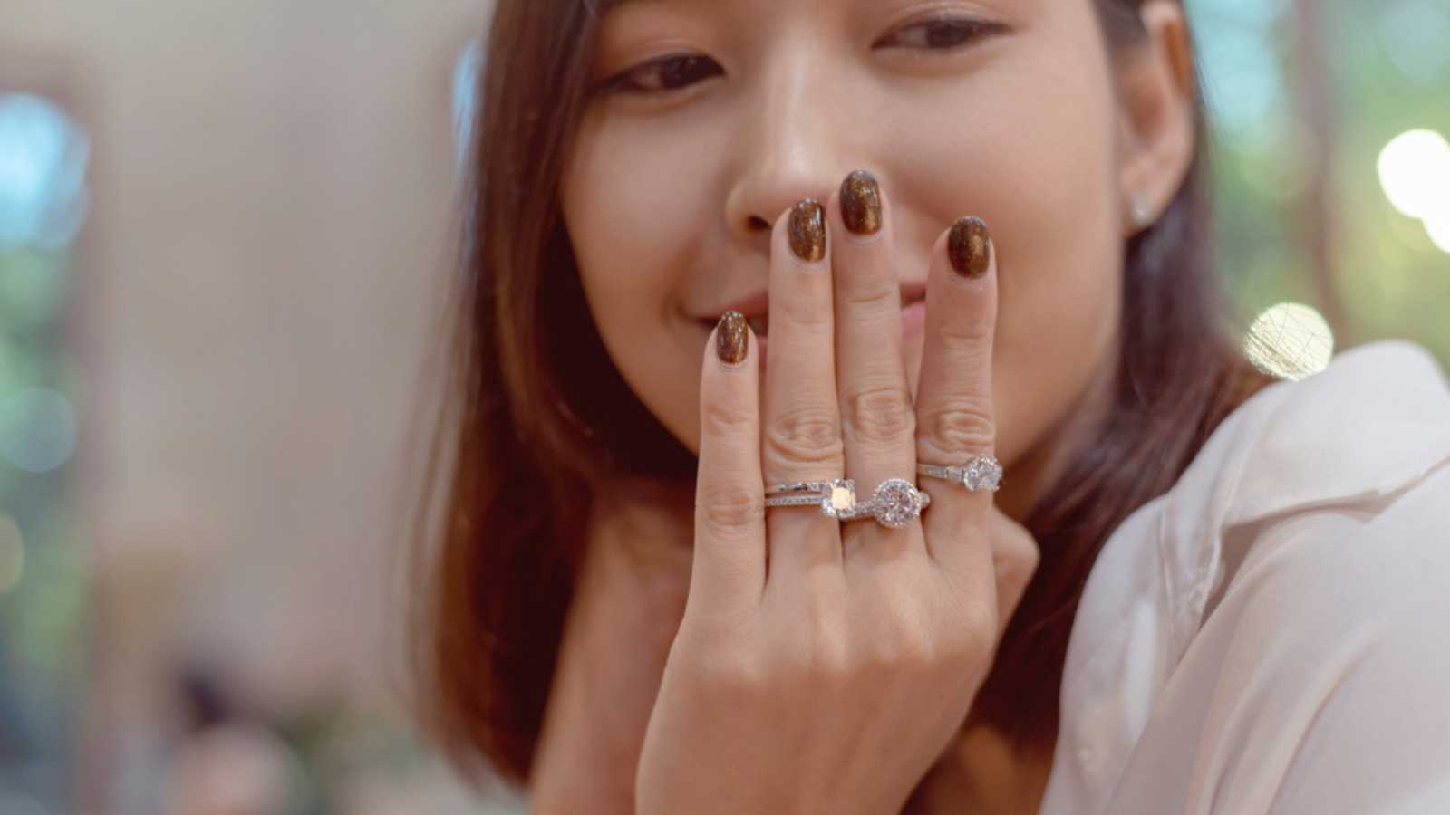 Woman Wearing Many Different Elegant Engagement Diamond Ring in Beautiful Girl Finger.
