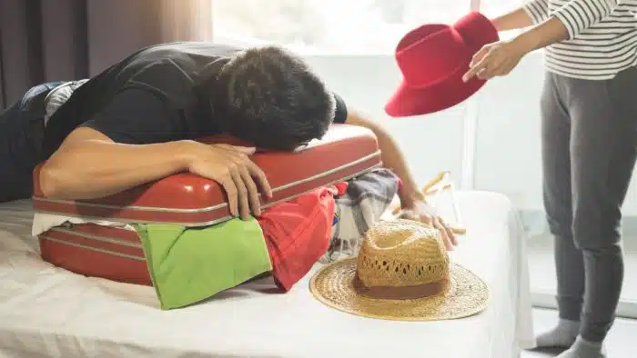 man and woman packing suitcase
