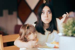 Funny mom eating with daughter