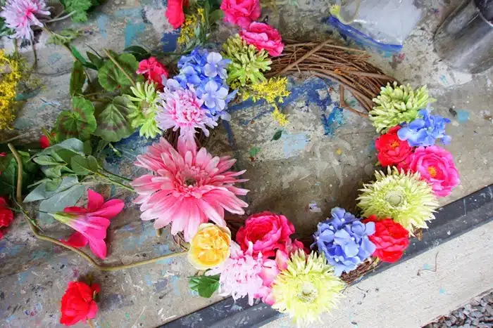 placing artificial flowers on a diy wreath