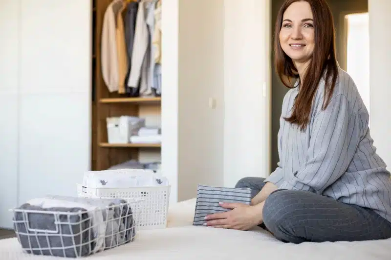 organizing clothing on a closet shelf