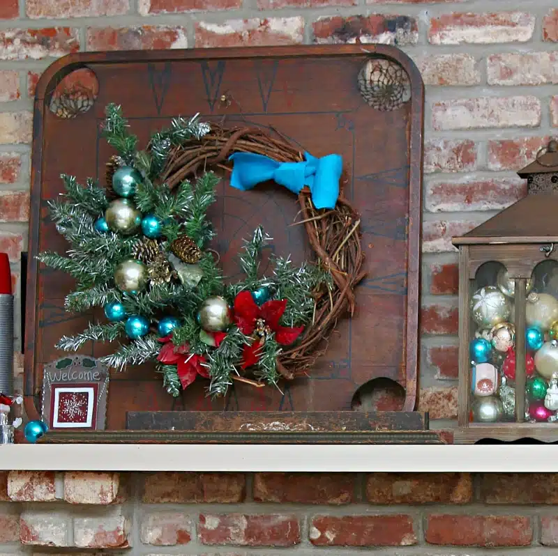 Christmas wreath hanging on a game board on the mantel 