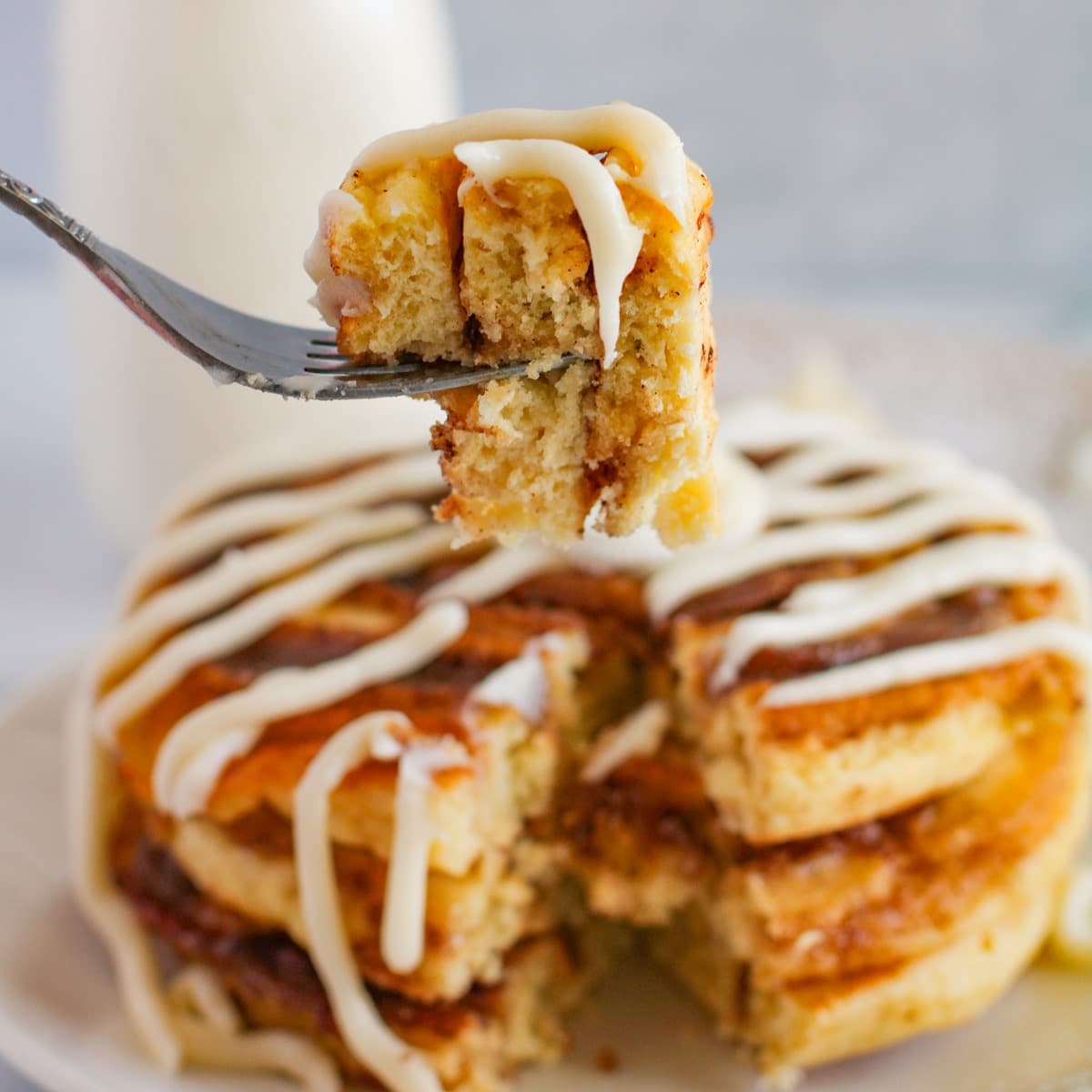 cinnamon roll pancakes with a cream cheese icing drizzle