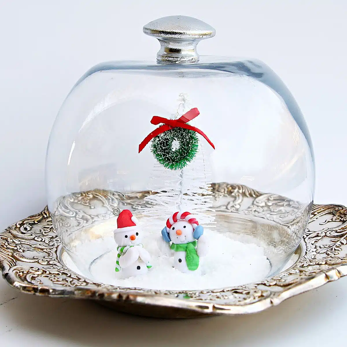 snow scene created with a silver plate dish and clear bowl globe 6