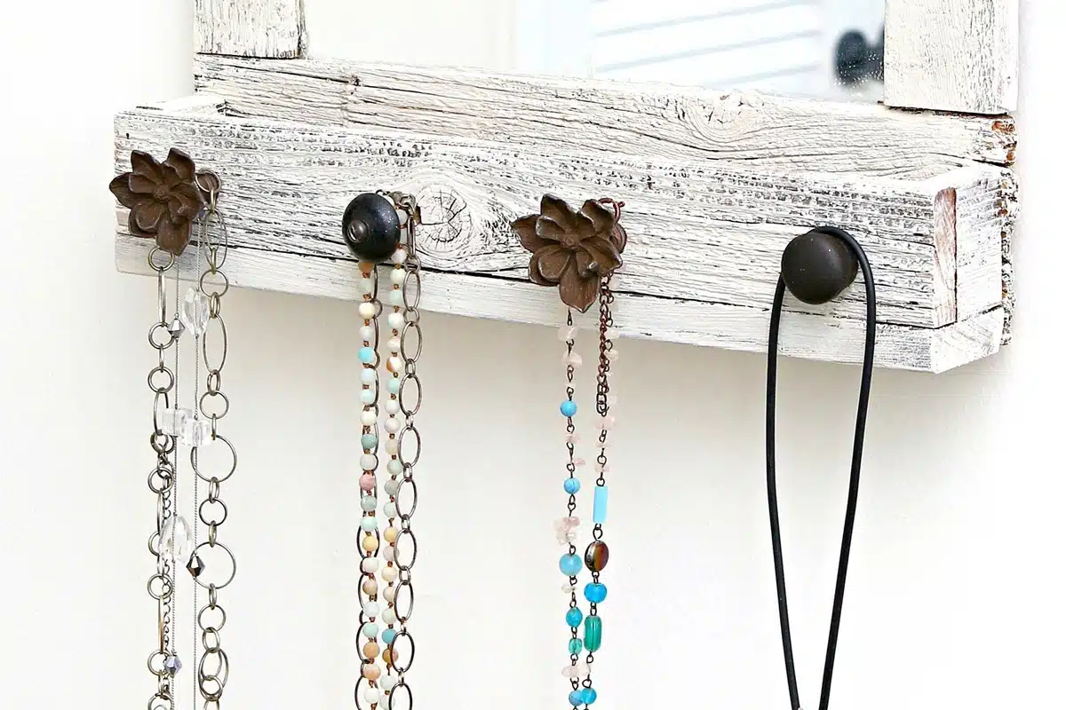 DIY farmhouse style wall mirror with attached furniture knobs for hanging jewelry