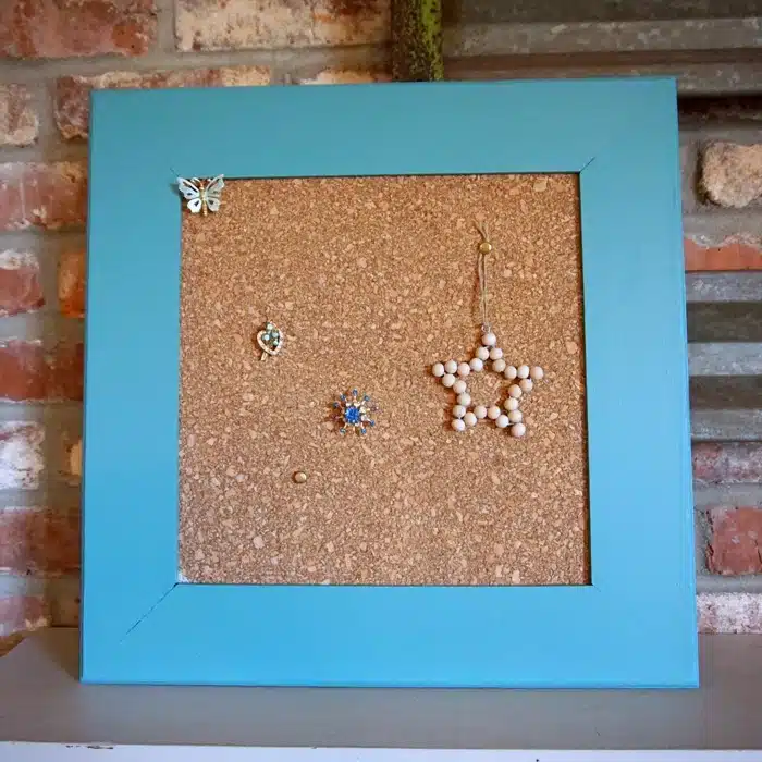 wood framed corkboard painted turquoise with decorative diy tacks