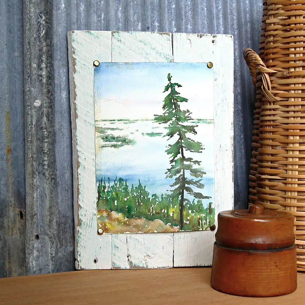 landscape painting tacked to reclaimed wood