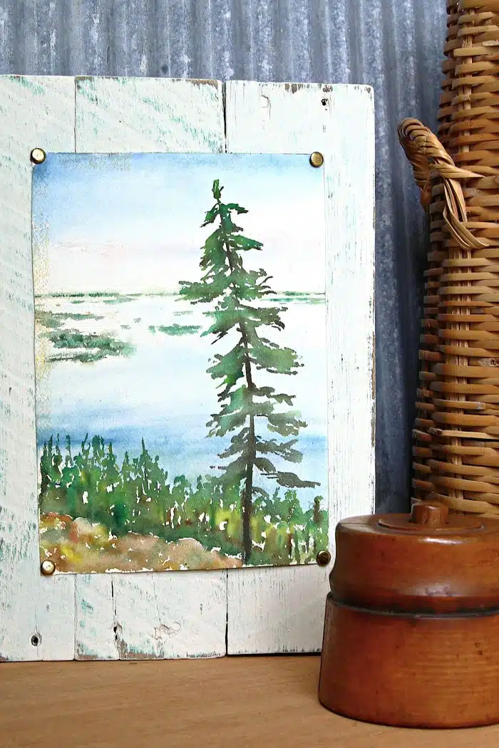 landscape painting tacked to reclaimed wood