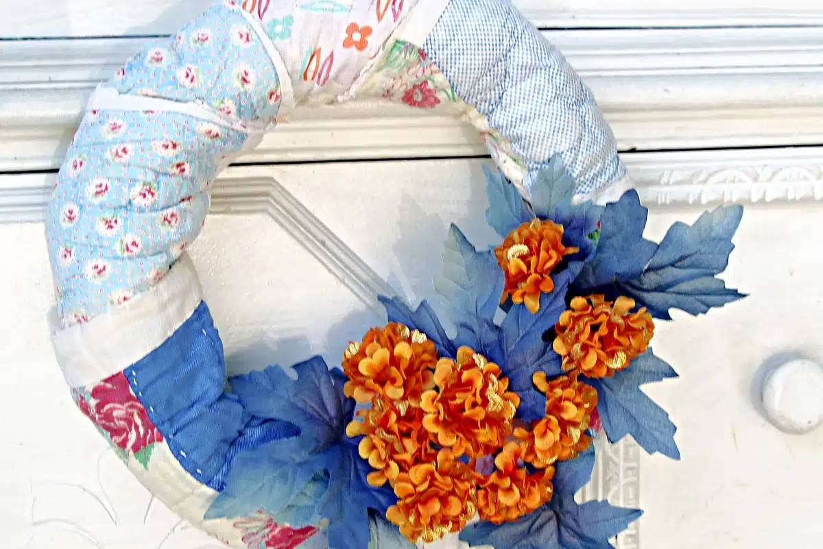 Fall wreath created with a vintage quilt and Dollar Tree flowers