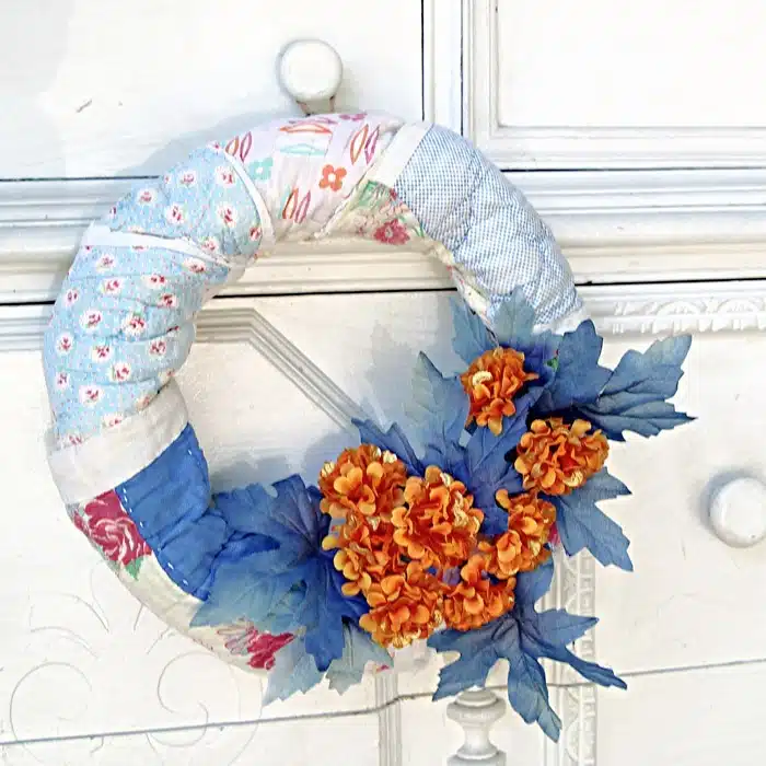 wreath made with a vintage quilt and Dollar Tree flowers