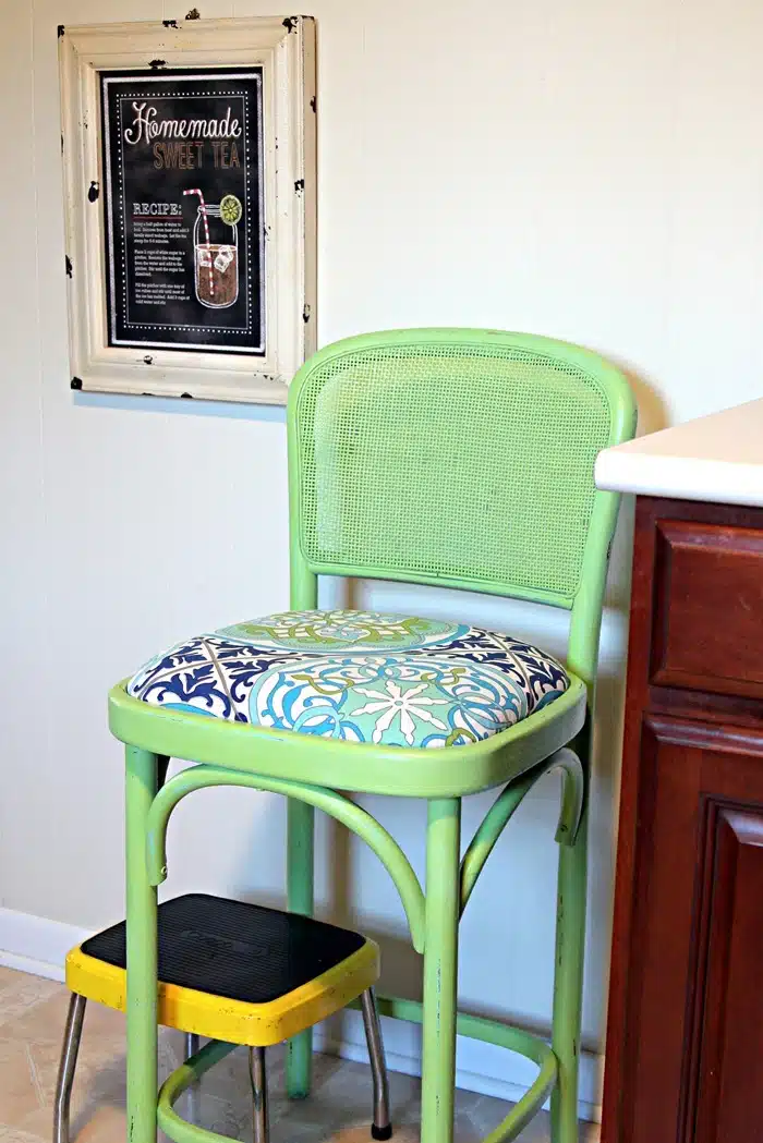 bamboo bar stool painted with spray paint and the seat is covered with new fabric