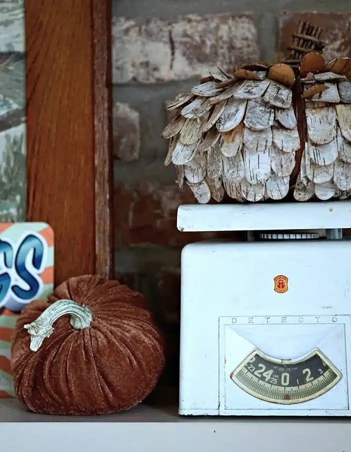 decorating a mantel for Fall with velvet pumpkins