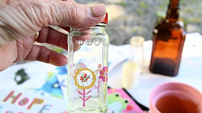 small jar or glass bottle decorated with Dollar Tree decals
