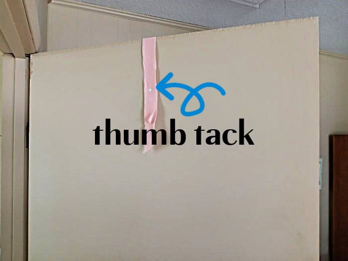 use a thumb tack on ribbon to hang a wreath on a door