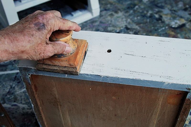 how to use a distressing block to add black distress marks to white furniture 1
